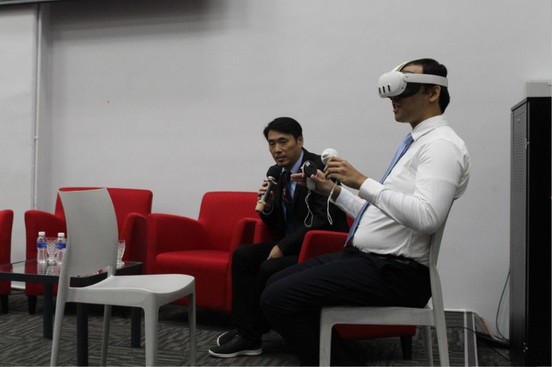 Ts John Hii Ing Kieng, Director, VORTEX XR Lab (left) explaining the integration of Extended Reality (XR) and Artificial Intelligence (AI) technologies during the demonstration of an immersive XR simulation.