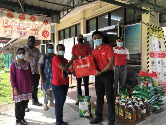Sunway Lost World of Tambun general manager Nurul Nuzairi distributing food aid to beneficiaries at SJK(T) Klebang, Chemor, Perak