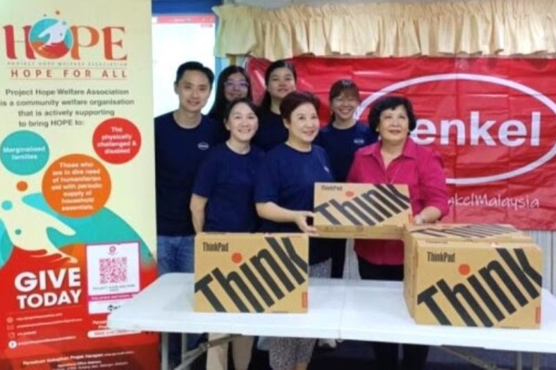 Teoh Tsu-Shien, President of Henkel Malaysia (front center), presents refurbished laptops to Lai Leen, Chairperson of Project Hope Welfare Association (front right).